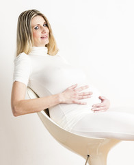 portrait of sitting pregnant woman wearing white clothes