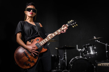 Young woman playing guitar during the concert