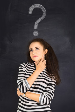 A shot of attractive young woman standing in front of blackboard