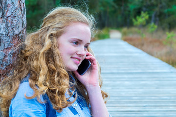 Blonde girl phoning mobile in nature