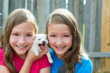 Twin sisters and puppy pet dog chihuahua playing