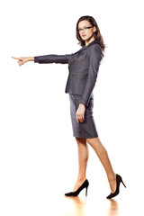 serious young beautiful business woman pointing at blank