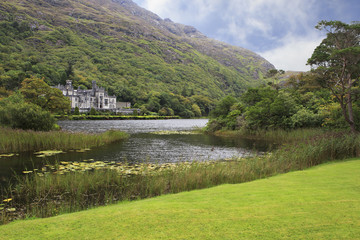 Fototapeta na wymiar Kylemore Abbey in mountains on the lake.
