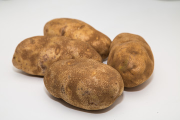 Fototapeta premium Four Potatoes on a White Counter
