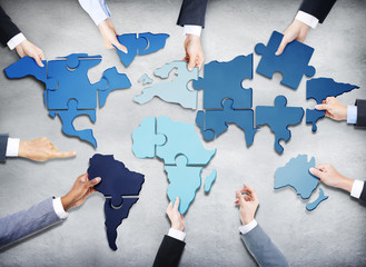 Business People with Jigsaw Forming in World Map