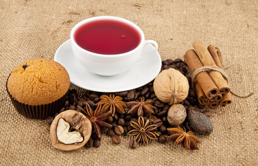 cakes, grains of coffee, seasonings and cup of floral tea