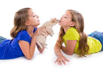 happy twin sister kid girls kissing puppy dog lying