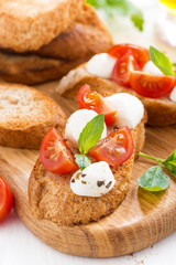 bruschetta with mozzarella, basil and cherry tomatoes, vertical
