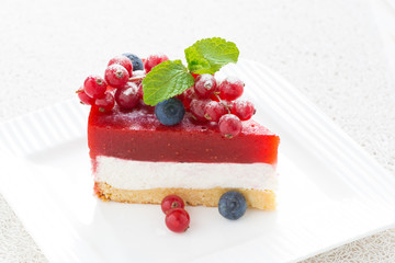 piece of cheesecake with strawberry jelly on a plate, close-up