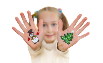 Happy girl demonstrating Christmas symbols painted on her hands.