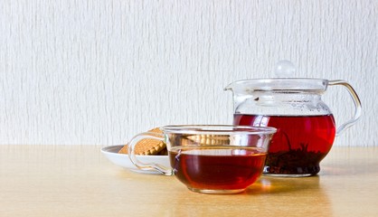 Strong black ceylon tea in glass teapot and cup with cookies