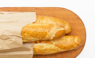 Baguettes packaged in a paper on a board on white background