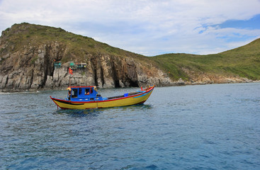 boat at sea on a background of rocks