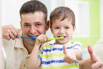 dad and child son brushing teeth in bathroom