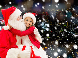 Fototapeta na wymiar smiling little girl with santa claus and gifts