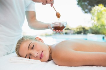 Obraz na płótnie Canvas Woman receiving spa treatment with honey