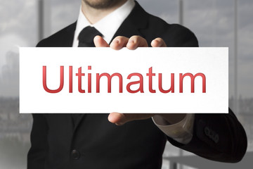 businessman holding sign ultimatum