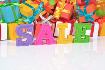 Fototapeta na wymiar Sale written by colorful letters on the background of gifts