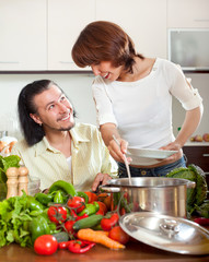 Man and woman with vegetables in kitchen