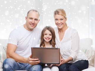 smiling family with laptop at home