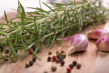 Rosemary bound with pepper and garlic on a wooden board 