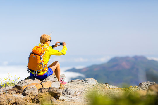 Woman hiker taking photos  in mountains