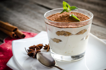 Tiramisu in the glass on the wooden background