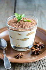 Tiramisu in the glass on the wooden background