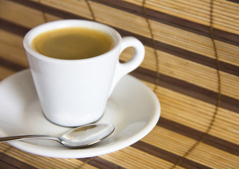 Espresso cup of coffee on straw placemat background