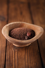 fine grated chocolate  and roasted cocoa beans  in old wooden bo