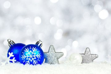 Blue and silver Christmas ornaments with twinkling background