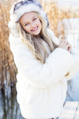 Cute little girl in winter clothes outdoors