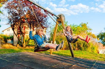 Adorable kids playing on a swing