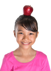 Young Asian Malay girl balancing a red apple on her head