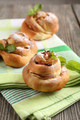 Tasty buns with berries on table close-up