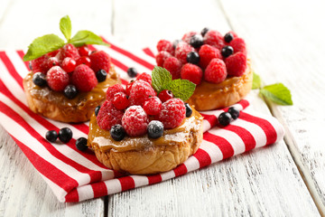 Sweet cakes with berries on table close-up