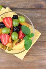 fresh tasty fruit salad on wooden table