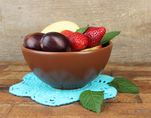 fresh tasty fruit salad on blue wooden table