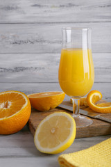glass of juice with fresh fruits on grey wooden table