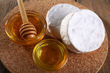 Camembert cheese and honey in glass bowl