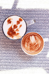 Cups of coffee with cute drawing in cafe