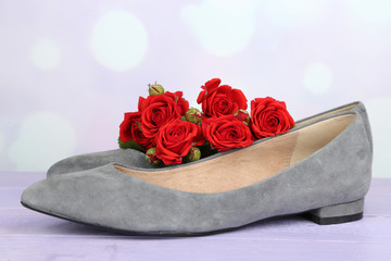 Beautiful woman shoes with flowers on bright background