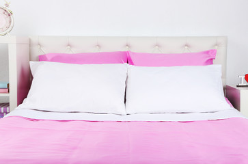 Bed in pink bed linen in room