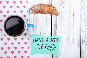 Composition of coffee, fresh croissant and paper card