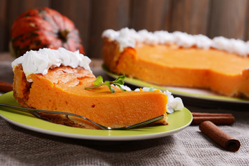 Piece of homemade pumpkin pie on plate on sackcloth background