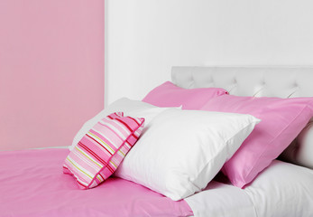 Bed in pink bed linen in room