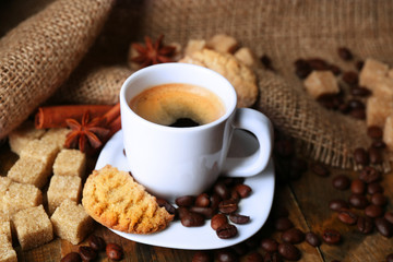 Cup of espresso and tasty cookie on wooden background