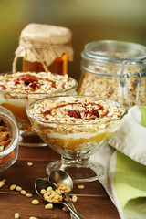 Tasty dessert with oat flakes and honey, on table