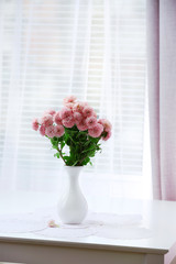 Beautiful flowers in vase with light from window