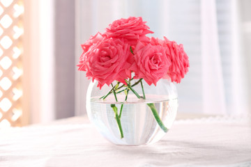 Beautiful flowers in vase with light from window